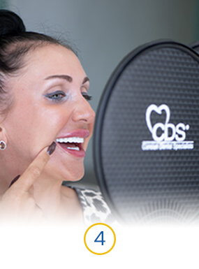 female patient at dental work mexico looking at her final veneers after cementation