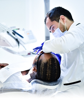 board certified dental specialist performing dental work on a patient